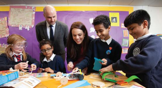 Kraig Brown, partnerships and development manager for Digital Xtra Fund and Kate Forbes, minister for public finance and digital economy, with pupils from Anderston Primary School in Glasgow